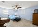 Bright bedroom with tile floors, ceiling fan, natural light, and a wooden dresser at 10900 Oakdale Ave, Port Richey, FL 34668