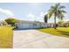 Well-kept single-story home featuring an expansive driveway, lush lawn, and attached garage at 10900 Oakdale Ave, Port Richey, FL 34668