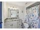 Well-lit bathroom featuring a modern vanity, and shower with decorative shower curtain at 13323 Susan Dr, Hudson, FL 34667