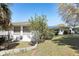 A backyard view of a well maintained single-Gathering home with green grass and a manicured lawn at 1407 Overlea St, Clearwater, FL 33755