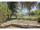 The backyard has a waterfront view with a pond and a brick retaining wall at 1407 Overlea St, Clearwater, FL 33755