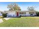 Charming single-story home with a well-maintained front yard and a vibrant red front door at 1407 Overlea St, Clearwater, FL 33755