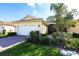Inviting home featuring lush landscaping, a two-car garage, and a beautiful red brick driveway at 16106 Amethyst Key Dr, Wimauma, FL 33598