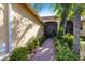 Pathway leading to the front porch surrounded by lush greenery and colorful plants at 16106 Amethyst Key Dr, Wimauma, FL 33598