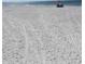 Sandy beach with a single person sitting under an umbrella in the distance at 1621 Gulf Blvd # 308, Clearwater Beach, FL 33767