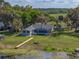 Aerial view of a home with a screened pool, and dock on a large lot of land at 18253 Townsend House Rd, Dade City, FL 33523