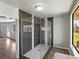 Modern glass shower with stylish tiling, complemented by scenic outdoor views at 18253 Townsend House Rd, Dade City, FL 33523