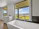 Bright bathroom with a standalone tub overlooking a peaceful lake view at 18253 Townsend House Rd, Dade City, FL 33523