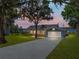 Charming single-story home with a well-manicured lawn and beautiful water view at sunset at 18253 Townsend House Rd, Dade City, FL 33523