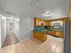 Open kitchen with tile floors, wood cabinets, and views into the hallway at 18253 Townsend House Rd, Dade City, FL 33523