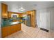 Bright kitchen features wood cabinetry, stainless steel refrigerator, and tile flooring at 18253 Townsend House Rd, Dade City, FL 33523