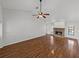 Bright living room featuring wood-look floors, a brick fireplace, and a ceiling fan at 18253 Townsend House Rd, Dade City, FL 33523