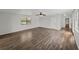 Bright living room featuring wood-look floors, a ceiling fan, and a large window at 18253 Townsend House Rd, Dade City, FL 33523