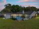 A screened pool is surrounded by lush landscaping, providing privacy and a relaxing atmosphere at 18253 Townsend House Rd, Dade City, FL 33523