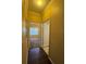 Inviting hallway with wood floors, leading to a bedroom with large window at 18575 Bridle Club Dr # 18575, Tampa, FL 33647