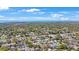 Aerial view showcasing a lush neighborhood with mature trees, homes, and proximity to a nearby thoroughfare at 1947 Citrus Hill Ln, Palm Harbor, FL 34683