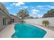 Gorgeous private pool with a white fence around the perimeter and lounge seating at 1947 Citrus Hill Ln, Palm Harbor, FL 34683