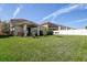 Expansive backyard featuring lush green grass, a covered patio, and a white fence, perfect for outdoor activities at 20220 Autumn Fern Ave, Tampa, FL 33647