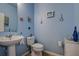 Powder room featuring light blue walls and nautical decorations above the toilet and vanity at 20220 Autumn Fern Ave, Tampa, FL 33647