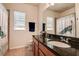 Well-lit bathroom boasting granite countertops, a large mirror, and modern fixtures at 20220 Autumn Fern Ave, Tampa, FL 33647