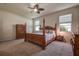 Spacious bedroom with large windows, a ceiling fan and a wooden four poster bed at 20220 Autumn Fern Ave, Tampa, FL 33647