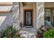 Inviting front entrance featuring a decorative glass door, manicured landscaping, and a cozy seating area at 20220 Autumn Fern Ave, Tampa, FL 33647