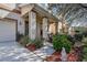 Inviting front porch with decorative columns, a small side garden, and a view of neighboring houses at 20220 Autumn Fern Ave, Tampa, FL 33647