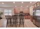 Kitchen island with stainless steel appliances, breakfast bar, tile floor, and wood cabinets at 20220 Autumn Fern Ave, Tampa, FL 33647