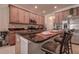 Open kitchen design features wood cabinets and a black countertop breakfast bar with chairs at 20220 Autumn Fern Ave, Tampa, FL 33647