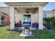 Covered patio with lounge furniture, fire pit and vibrant greenery overlooking backyard at 20220 Autumn Fern Ave, Tampa, FL 33647