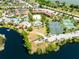 Aerial view showcases a resort's amenities: pools, tennis courts, buildings, landscaping and a lake at 21011 Picasso Ct # 101, Land O Lakes, FL 34637