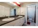 Bathroom featuring double sinks with white cabinets, a large mirror, and access to a separate toilet and shower area at 21011 Picasso Ct # 101, Land O Lakes, FL 34637