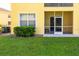 View of exterior with screened patio, a window, a bush, air conditioner and lawn at 21011 Picasso Ct # 101, Land O Lakes, FL 34637