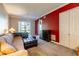 Cozy living room with comfortable seating, red accent wall, and sliding glass door at 21011 Picasso Ct # 101, Land O Lakes, FL 34637