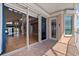 Relaxing outdoor balcony with patio furniture, an open door, and a view of the living room at 218 Sand Key Estates Dr, Clearwater Beach, FL 33767