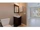 Neutral bathroom with a single vanity, wood floors, and adjacent room with a big window at 218 Sand Key Estates Dr, Clearwater Beach, FL 33767