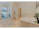 Relaxing bathroom with a large soaking tub, tile accents, and views into the main bedroom at 218 Sand Key Estates Dr, Clearwater Beach, FL 33767
