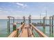 View down the dock of the boat lift and open bay in this waterfront home at 218 Sand Key Estates Dr, Clearwater Beach, FL 33767