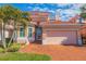 Charming home featuring a clay tile roof, two-car garage, brick driveway, and mature landscaping at 218 Sand Key Estates Dr, Clearwater Beach, FL 33767