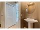 Charming half bath featuring a pedestal sink, round mirror, and neutral paint at 218 Sand Key Estates Dr, Clearwater Beach, FL 33767