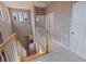 Bright hallway with arched windows, wood staircase, and neutral walls, creating an inviting transition between floors at 218 Sand Key Estates Dr, Clearwater Beach, FL 33767