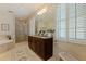 Large main bathroom with tiled shower, standalone tub and a large granite-topped vanity with double sinks at 218 Sand Key Estates Dr, Clearwater Beach, FL 33767