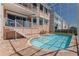 Backyard with a screened-in pool, brick patio, stairs leading to a balcony, and lush landscaping at 218 Sand Key Estates Dr, Clearwater Beach, FL 33767
