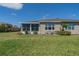 Well-kept backyard featuring screened-in lanai, green lawn, and charming landscaping at 2234 Nottingham Greens Dr # 2234, Sun City Center, FL 33573