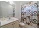 Bright bathroom with white vanity, framed mirror, and shower with patterned curtain at 2234 Nottingham Greens Dr # 2234, Sun City Center, FL 33573