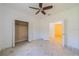 Bedroom featuring neutral tile flooring, ceiling fan, and closet with open doors at 2234 Nottingham Greens Dr # 2234, Sun City Center, FL 33573