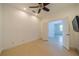 Bedroom showcasing neutral tile flooring, a ceiling fan, and a television on the wall at 2234 Nottingham Greens Dr # 2234, Sun City Center, FL 33573