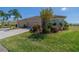 Home exterior featuring lush landscaping, mature palm trees, and a three-car garage at 2234 Nottingham Greens Dr # 2234, Sun City Center, FL 33573