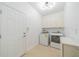 Bright laundry room with appliances, cabinets, tile floors and recessed lighting at 2234 Nottingham Greens Dr # 2234, Sun City Center, FL 33573