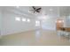 Bright, open-concept living space featuring tile floors, a ceiling fan, and adjacent kitchen at 2234 Nottingham Greens Dr # 2234, Sun City Center, FL 33573